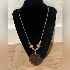 Silver Chainnecklace featuring a carved jade pendant and decorative beads